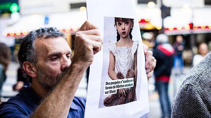 A protester at a department store in Paris where Shein plans to open its first permanent outlet