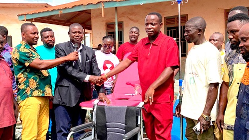 Dominic Bonsu (2nd from right), Assembly Member for Manso Takorase, handing over a wheelchair in a symbolic gesture to Yaw Opoku, the District Planning Officer 