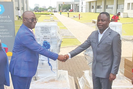 Kwabena Mintah Akandoh (right),  Minister of Health, in a handshake with Dr Abdul-Samed Tanko, CEO, UGMC, after the  presentation. Picture: ERNEST KODZI
