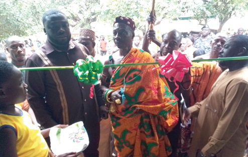 Nana Gyasi, the Chief of Gyasikrom and Benkumhene of Asakyiri, cutting the tape to inaugurate the school block. Looking on is Dr Frank Amoakohene (left), the Ashanti Regional Minister 