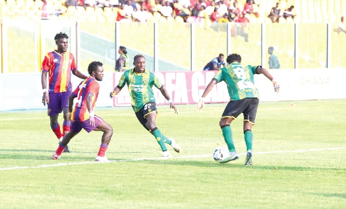 • Kotoko’s Lord Adamu traps the ball as Hearts markers close in on him during the game yesterday