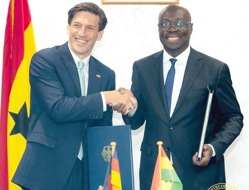 Dr Cassiel Ato Forson (right), Minister of Finance, and Frederik Landshöft, German Ambassador to Ghana, in a handshake after the signing ceremony