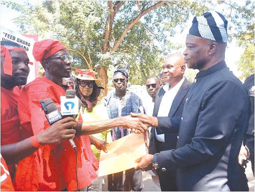 Alhaji Saibu Braimah (left),  Chairman of Association of Ghana Rice Producers and Processors, presenting a petition to Ali Adolf John (right), Northern Regional Minister, after the protest