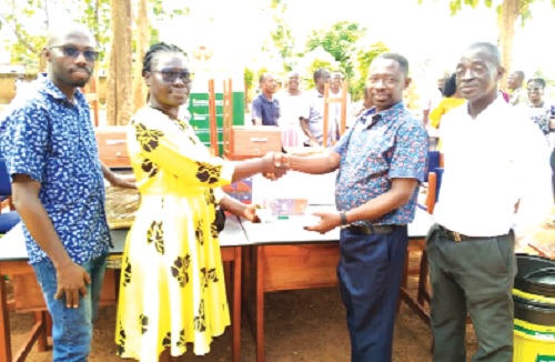 Lily Opoku Mensah (2nd from left), Corporate Social Responsibility Sustainability Officer, ASA Savings and Loans Ltd, presenting the items to Augustine Boadu-Gyamfi, Headmaster of the school