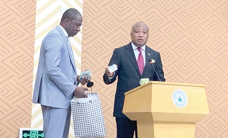 Samuel Okudzeto Ablakwa (right), Minister of Foreign Affairs, displaying one of the confiscated Ghana Cards. With him is Yahaya Amantana Mahama (left), Director, Passport
