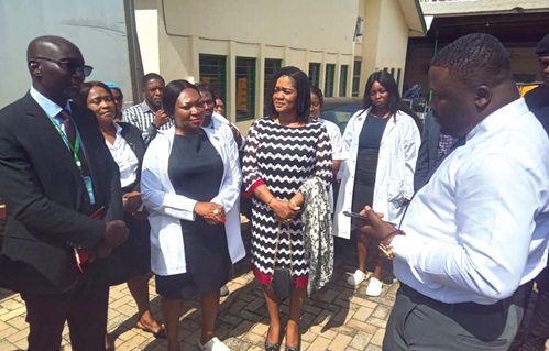 Dr Frank Amoakohene (right), Ashanti Regional Minister, interacting with Dr Fred Adomako-Boateng (left), the Ashanti Regional Director of Health Services, and other staff during a visit to the regional medical stores