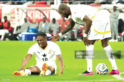 Francis Abu writhes in agony after suffering a broken leg, while teammate Kwasi Sibo (right) rushes to comfort him