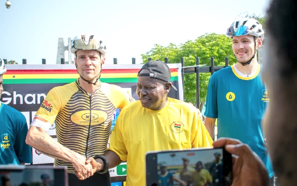Nana Mankattah, an Executive Member of the GOC, congratulating Stage 1 winner, Philip Bachi of Team Obroni