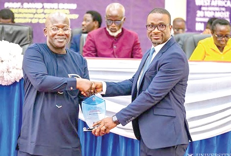 Prof. Eric Yirenkyi Danquah (right), Director of WACCI and  Chairman of the Governing Board of the Ghana National Research  Fund, presenting an award to Prof. David Teye Doku, Director of DRIC 
