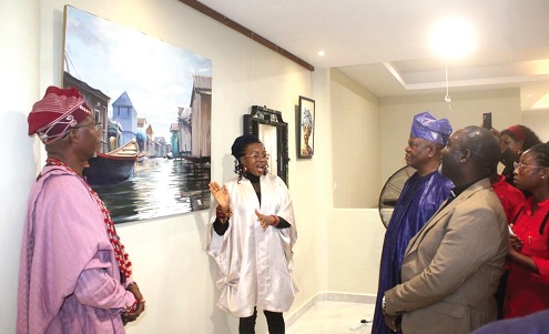 Tabitha Odigili (middle), an artist and exhibitor, explaining her works to Moses Ifedayo  Adeoye (right), Nigerian High Commissioner to Ghana, and other participants