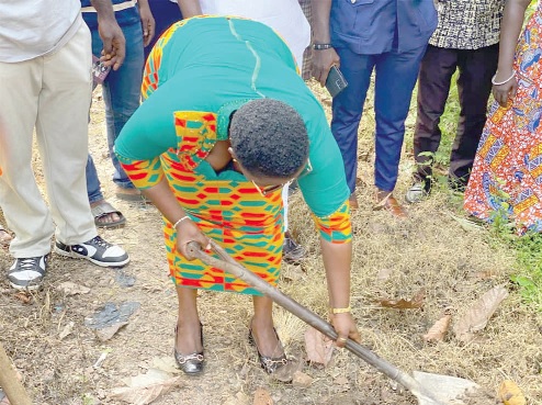 Paulina Akabila, the West Akim Municipal Chief Executive, with the axe, cutting the sod for work to begin