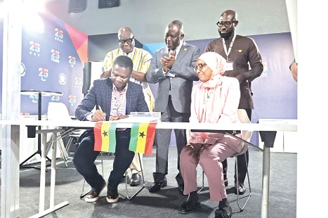 Dr Glenn Gyimah (left), General Manager of Jospong Green Transition Office, signing the MoU with Prof. Fatima Denton, Director of the UNU-INR at COP30
