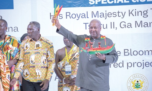 President John Dramani Mahama displaying a miniature fishing canoe presented to him at the conference