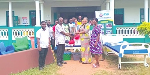 Gideon Asante Yeboah (2nd from right), Area Manager of ASA Savings and Loans, Central Division,  presenting the items to Suzzy Bill, the District Director of Health Services. 