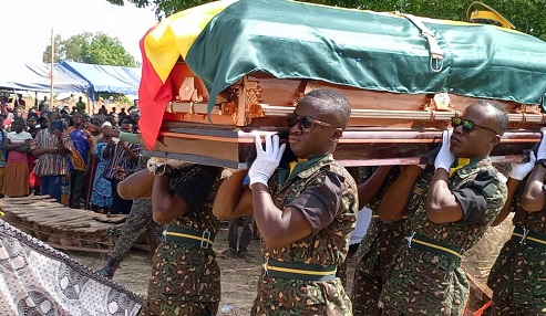Pallbearers carrying the coffin with the remains of AICOI Cosmos Dakurah, their slain colleague, to the cemetery