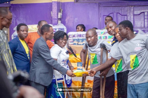Deconness Prof. Augustina Naami (3rd from left), National Executive Committee member, Ministry to Persons with Disabilities  of the Church of Pentecost, presenting some items to Reuben Abuanor (4th from right), Chairperson of the Ghana Society of the Physically Disabled for the Tema Metropolis­