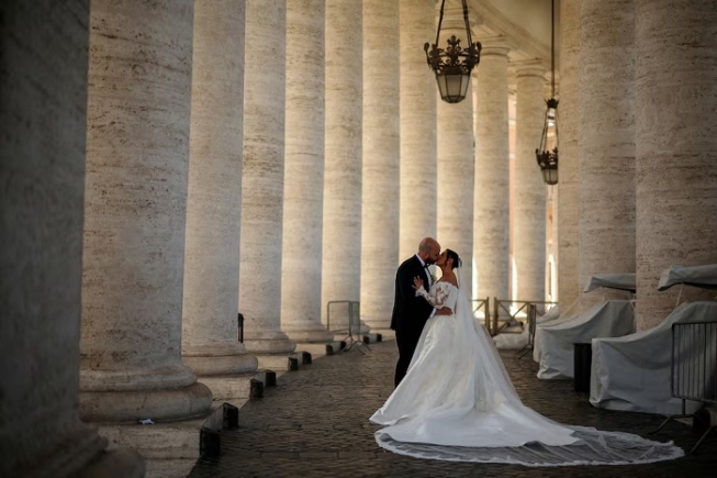 A couple kiss during their wedding photo session under the Vatican colonnade in the Vatican, April 29, 2025. REUTERS/Stoyan Nenov/File Photo