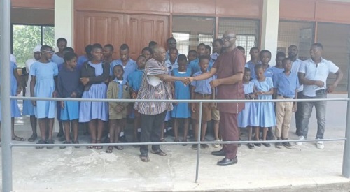 Dr Bill Yeboah Kyeremeh (right), Chief Information Officer of ASA Savings and Loans Limited, handing over the building to Sylvanus Apiribu, Senior House Master of the school. Looking on are some of the students of the school