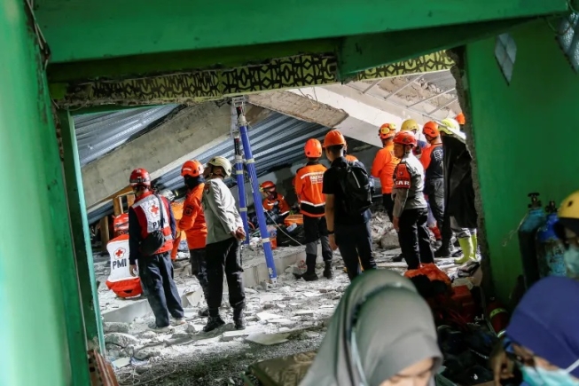 Search and rescue officers stand amid the rubble of a collapsed building, at Al Khoziny Islamic Boarding School in Sidoarjo, East Java, Indonesia, September 30, 2025 [Dipta Wahyu/Reuters]