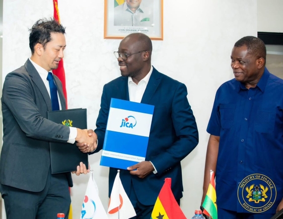 Dr Cassiel Ato Forson (middle), Finance Minister, exchanging signed documents with Oda Ryotaro, Senior Representative, JICA Ghana. With them is Kwame Governs Agbodza, Minister of Roads and Highways