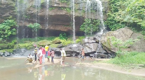 Some revellers at the foot of the waterfall