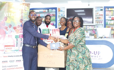 Dr Isaac Nyantakyi (left), Head of Sales and Marketing, Top-Up Pharmacy, presenting the donated drugs to Yvonne Dasoebri (right), Corporate Communications Officer, Graphic Communications Group Ltd. With them is Dr George Anagli (2nd from left), Deputy Head of Sales and Marketing