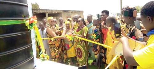 Rita Akosua Adjei Awatey, the Eastern Regional Minister, cutting the ribbon to inaugurate the borehole.