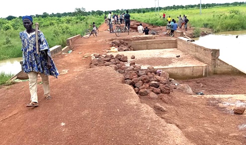 A bridge gradually being washed away by floods