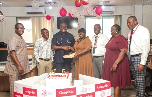 Theophilus Yartey (3rd from left), Editor, Graphic, receiving an envelope from Phoebe Odoom (4th from right), Sales and Marketing Coordinator of Labadi Beach Hotel, in the Graphic newsroom. Picture: CALEB VANDERPUYE