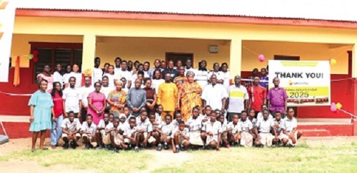 The national service persons in white with the children and staff of the school and the bank after the inauguration 