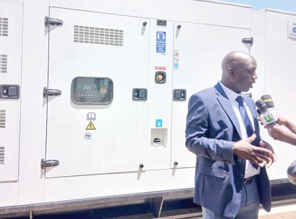 Dr Yakubu Seidu Adam, CEO of Korle Bu Teaching Hospital, addressing the media. Behind him is the donated  generator