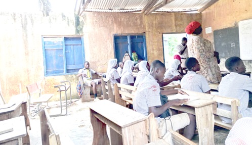 Pupils studying in a classroom with part of its roof ripped off