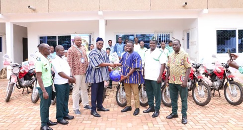 Daniel Yakuba (4th from left), MEAL Cordinator of CRS, presenting the motorcycles to Dr Patrick Inkoom (3rd from right), Deputy CEO of National Ambulance Service
