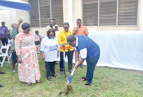 Nana Owiredu Wadie (with pick-axe), Nkosuohene of Kwahu-Nkwatia, cutting the sod for construction work to start. Looking on are the staff of the Kabaka Foundation and the management of the hospital  
