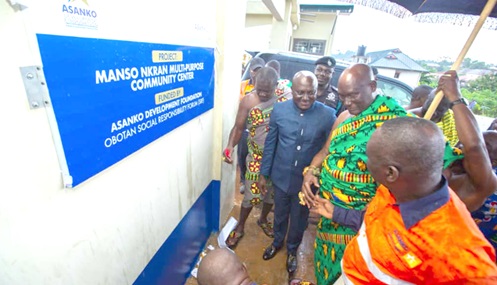 Nana Bi-Kusi Appiah (2nd from right), Paramount Chief, Manso Nkwanta, in a handshake with Dr Charles Amoah (right), Managing Director, Asanko Gold Ghana Limited, after he cut a tape to unveil a plaque to inaugurate the facility. Those with them include Benjamin Marfo (2nd from left), DCE, Amansie South.