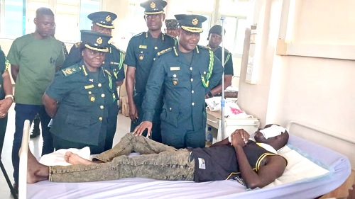 Samuel Basintale Amadu (right), Comptroller-General of the Ghana Immigration Service, interacting with the injured officer at the Tamale Teaching Hospital. With him are other senior officers