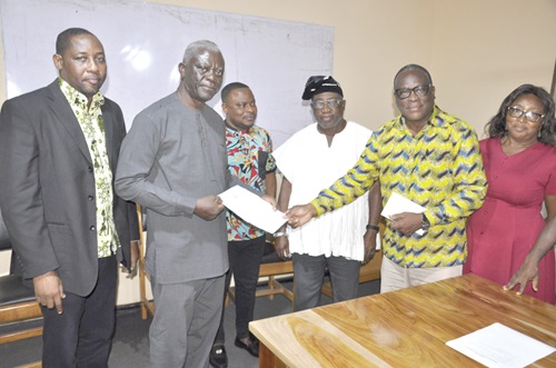 Professor Tsatsu Adogla-Bessa (2nd from right), outgoing acting President of EPUC, presenting the handover notes to Prof. Kenneth Kodzo Nyalemegbe (2nd from left), President, EPUC, while George Kwaku Debrie (in smock), Registrar, and others look on