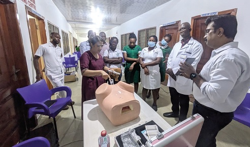 Veena Moktali (left) and Koustubh Naik (right), co-founders of Periwinkle Technologies,  demonstrating how the Smart Cope device works to Dr Kofi Effah (2nd from right) and the team at the CCPTC, Battor