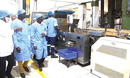 Edward Obeng (left), the Production Manager of NutriFoods Ghana Limited, conducting the members of the committee round the company's factory