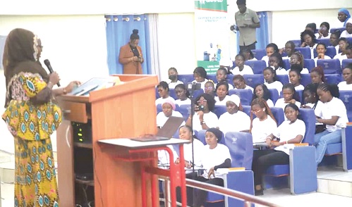Fairuza Abdul-Rashid Safian (standing), Executive Director, CAMFED Ghana, speaking at the 2025 Tertiary Convening orientation held at KNUST in Kumasi.