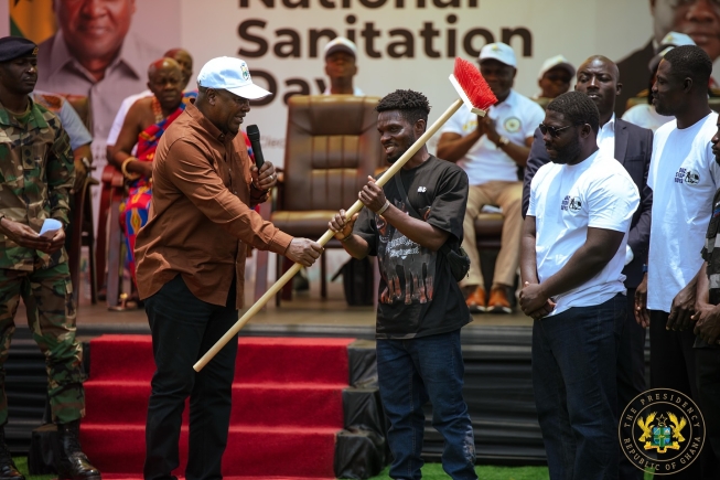 President John Mahama (left) interacting with Heneba Kojo Sarfo (2nd from left), the leader of Bus Stop Boys, and other members after the presentation of a standing brush as part of the essential sanitation tools donation President John Mahama (left) interacting with Heneba Kojo Sarfo (2nd from left), the leader of Bus Stop Boys, and other members after the presentation of a standing brush as part of the essential sanitation tools donation