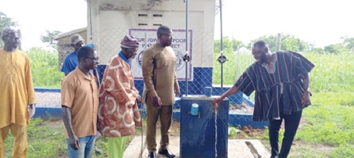Seth Kponyo (right), PURC Regional Manager, opening the tap for water to flow from one of the boreholes, while Joseph Akaseje Abaa (2nd from right), Bongo DCE, and other guests look on Seth Kponyo (right), PURC Regional Manager, opening the tap for water to flow from one of the boreholes, while Joseph Akaseje Abaa (2nd from right), Bongo DCE, and other guests look on