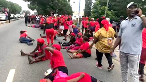 Some of the traders clad in red sitting down on the street during the protest yesterday 