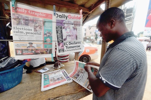 A reader at a newspaper stand sampling the various newspapers