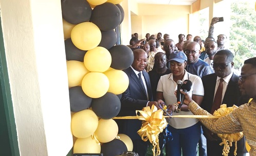 Ebi Bright (middle), MCE for Tema, being assisted by Kodjo Nunekpeku (left), Board Chairman, Tema Lube Oil Company Ltd, and Amos Donkor (right), Managing Director of Tema Lube Oil Company Ltd, and other dignitaries to cut the ribbon to inaugurate the refurbished physics laboratory 