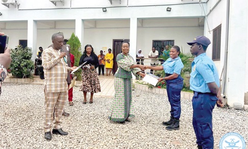 Ewurabena Aubynn (left), MP for Ablekuma North, presenting a certificate to one of the female Community Police Assistants at the event