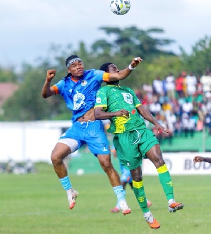 Razak Simpson -- Nations FC captain challenges an opponent for the ball Razak Simpson -- Nations FC captain challenges an opponent for the ball