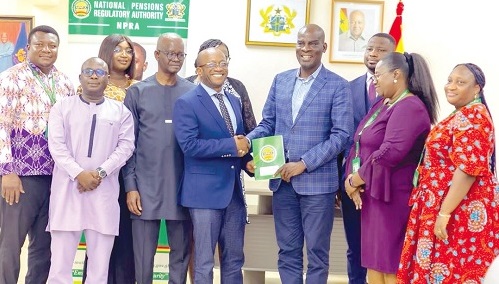 Chris Boadi-Mensah (4th from left), NPRA boss, presenting a copy of the exercise book to Haruna Iddrisu, the Education Minister