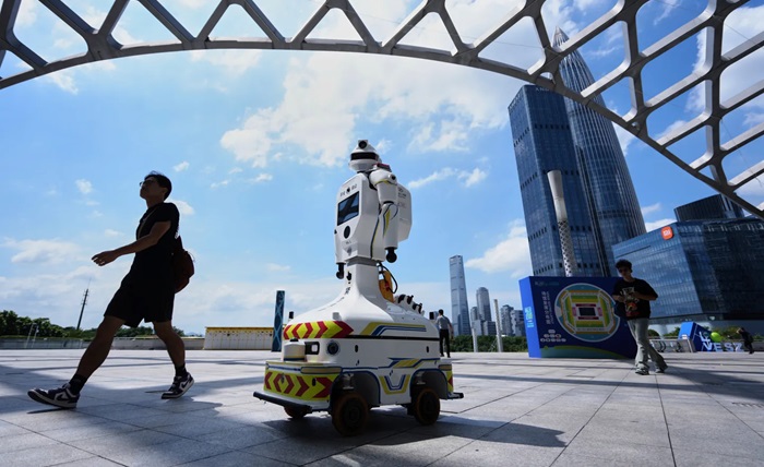 People walk past a robot at the Shenzhen Bay Sports Center Arena, in Shenzhen, China, on September 18, 2025. / AP
