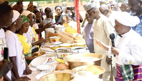 Failatu Abdul-Razak (right), the main chef at the event, showing the various dishes to patrons